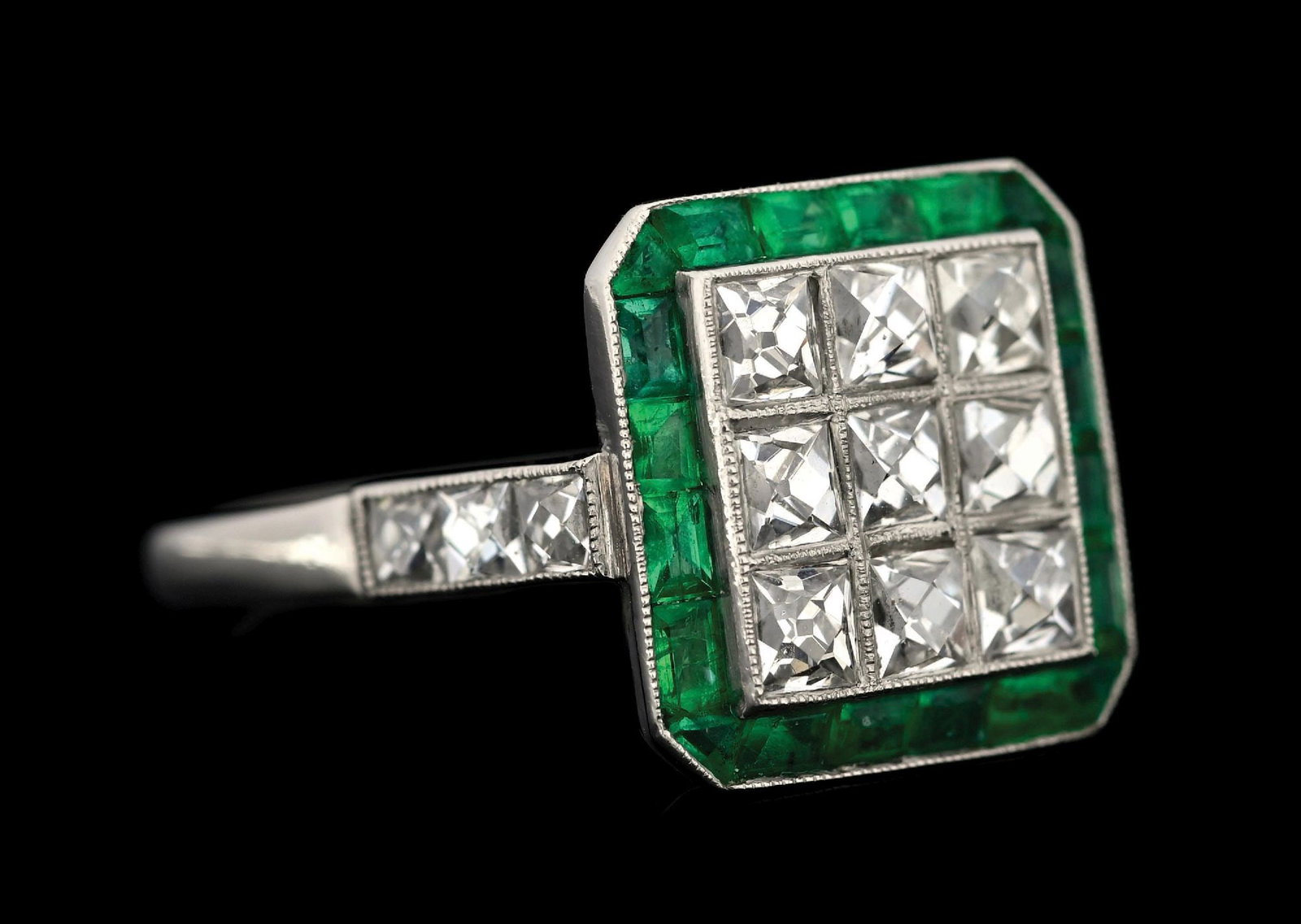 PLATINUM ART DECO EMERALD & DIAMOND RING: Platinum Art Deco emerald and diamond ring consisting of 15 square French cut diamonds with an estimated total weight of 1.50cts along with a border of 20 mixed cut emeralds. Finger size 7-1/4. Top me