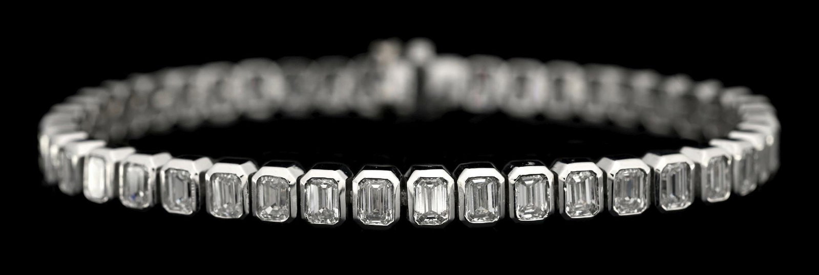 PLATINUM EMERALD CUT DIAMOND BRACELET, 10.12CT TW: Platinum and diamond bracelet consisting of 45 bezel-set emerald cut near-colorless natural diamonds with a total weight of 10.12cts. Length measures 7-1/8". Width measures 5mm. Gross weight is 28.0