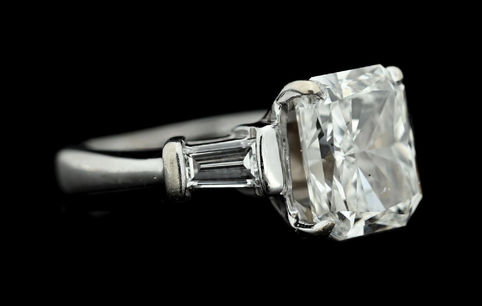 14K WHITE GOLD 4CT RADIANT-CUT DIAMOND RING W/GIA REPORT: Ladies' 14k white gold diamond engagement consisting of 1 radiant cut natural diamond weighing 4.00cts, graded J color, SI1 clarity, with 2 tapered baguette cut natural diamonds with a total weight