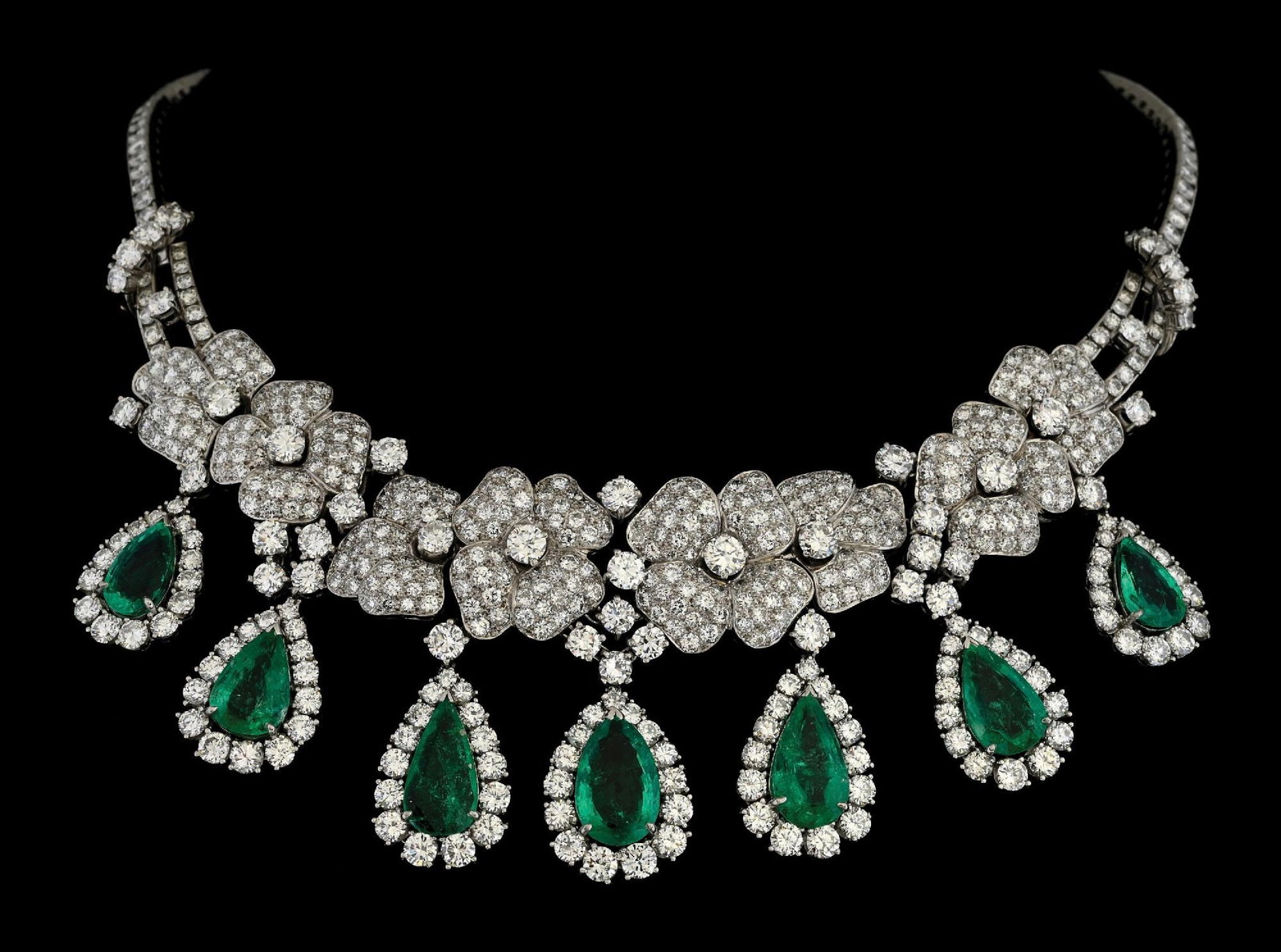 PLATINUM EMERALD & DIAMOND FLOWER ESTATE NECKLACE: Stunning estate platinum emerald and diamond flower necklace consisting of 7 pear shaped faceted emeralds measuring from 14.5x9mm (largest) to 11.5x6.5mm (smallest) with an estimated total weight of 1
