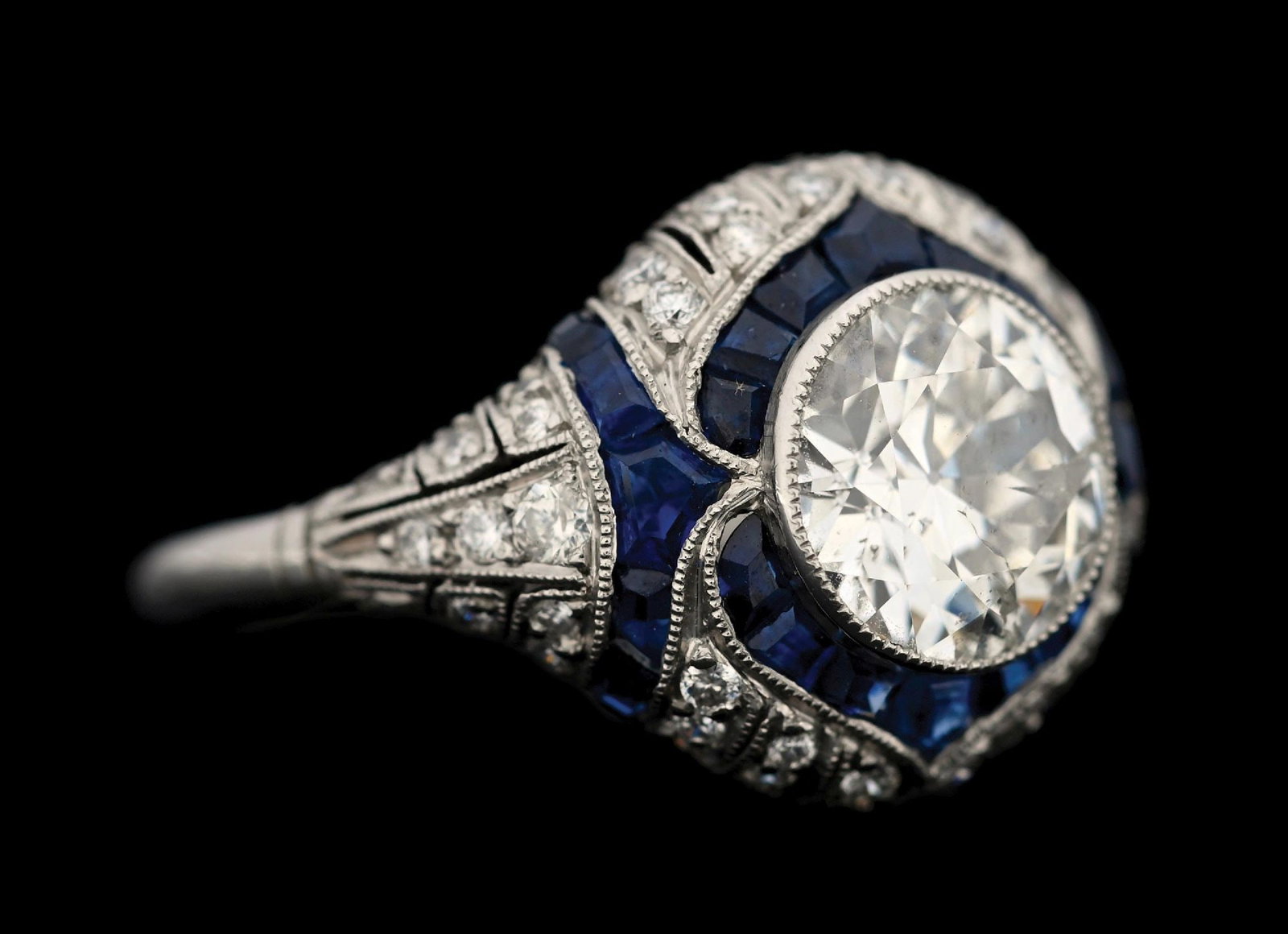 PLATINUM ART DECO DIAMOND & SAPPHIRE FILAGREE RING: Platinum Art Deco emerald and diamond filagree ring consisting of 1 round European cut natural diamond weighing 1.58cts (approximate grading SI2/SI3 clarity, I/J color), 62 round cut natural diamonds 