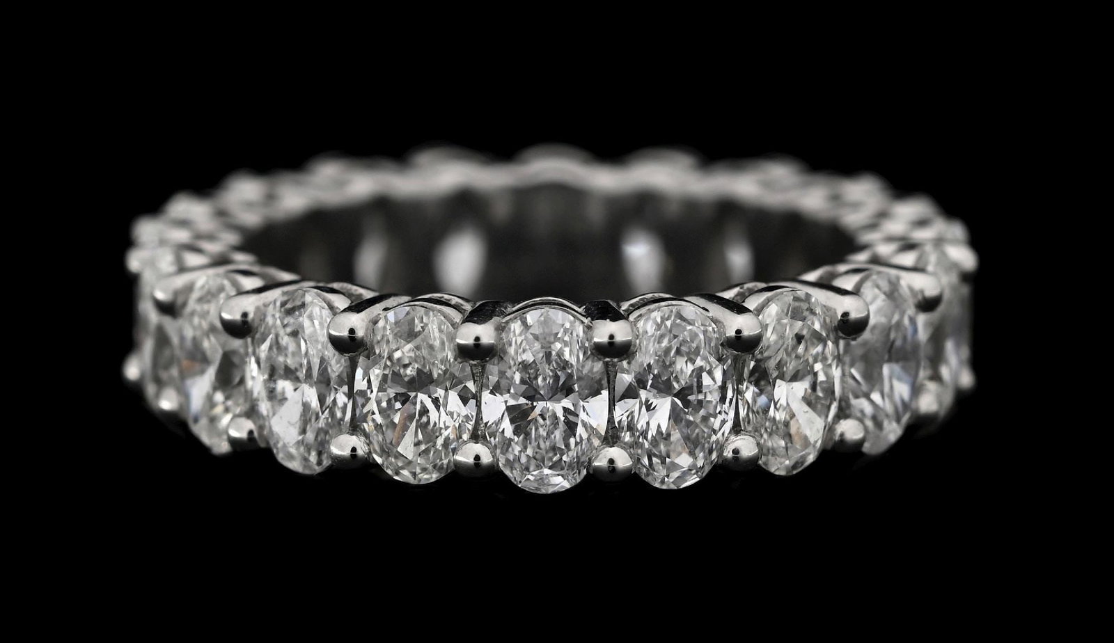 PLATINUM OVAL DIAMOND ETERNITY BAND, 5.04CT TW: Platinum diamond eternity band consisting of 20 oval brilliant cut near-colorless natural diamonds with a total weight of 5.04cts. Width measures 5mm. Finger size 6-1/4. Gross weight is 8.3 grams.