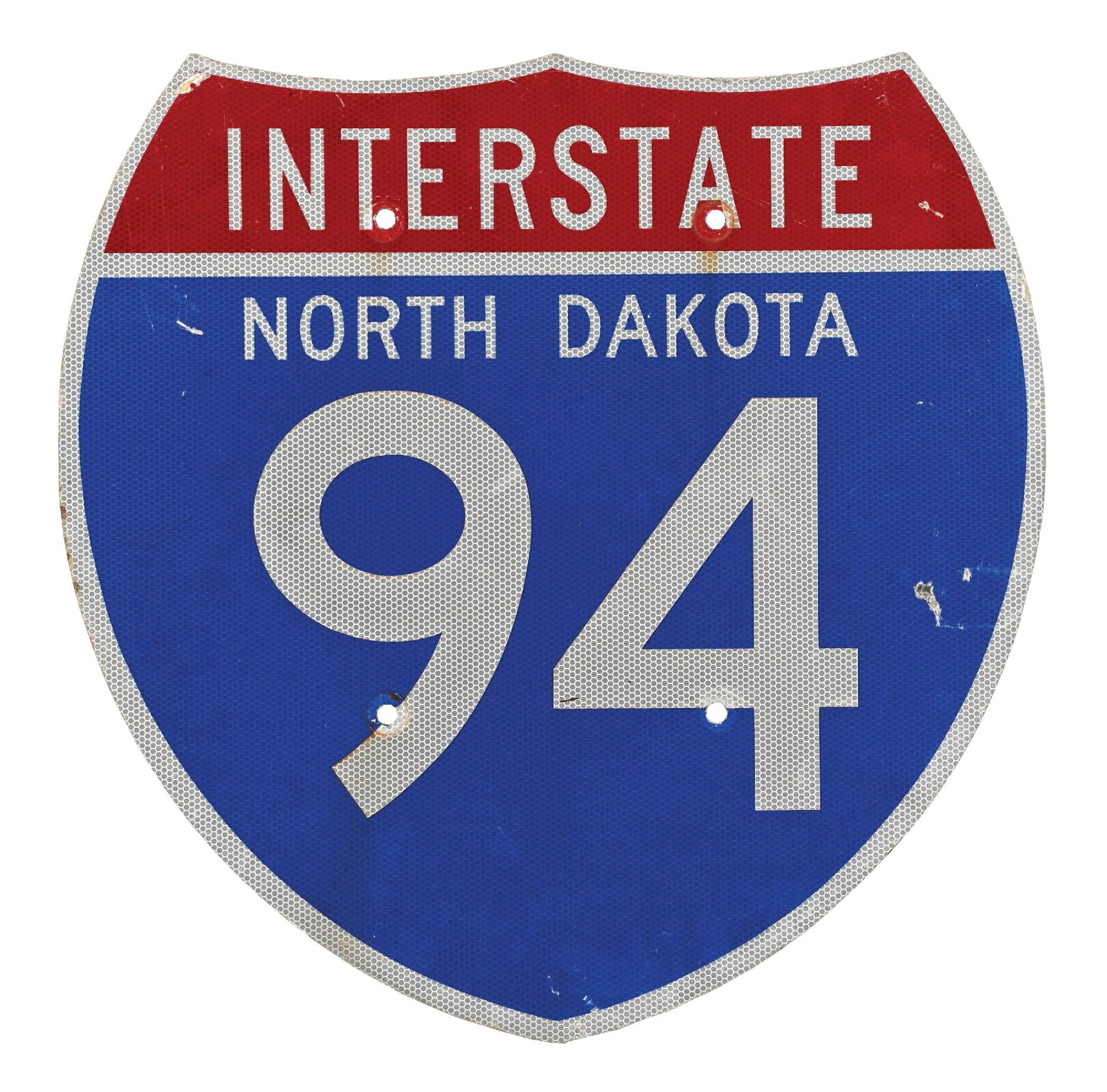 NORTH DAKOTA INTERSTATE 94 REFLECTIVE ALUMINUM SHIELD SIGN: Single-Sided Aluminum Sign. CONDITION: Overall very good, showing bright color & gloss with a reflective surface. Areas of general age wear and surface scratching present with areas of wear along the 