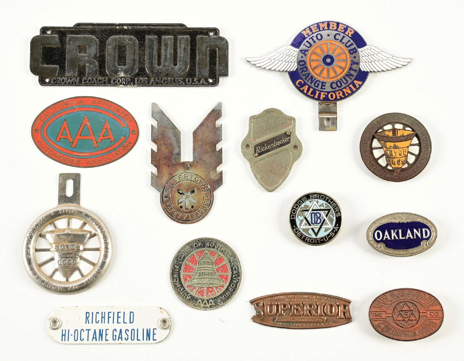 COLLECTION OF 13: ASSORTED CAR RADIATOR BADGES AND LICENSE TOPPERS: Collection Consists Of: Various Automobile Radiator Badges and License Plate Toppers. CONDITION: Each in good condition showing general age wear with a few pieces showing heavier wear. Lot also includ