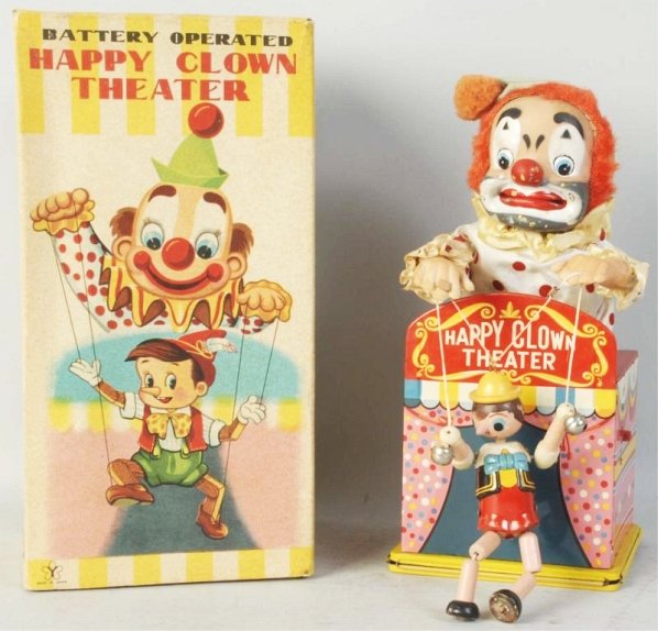 Japanese Battery-Operated Pinocchio Toy.: Vinyl, tin, and wood. Marked "Happy Clown Theater". Depicts clown as the puppet master of Pinocchio. Vinyl clown face has some damage. Toy has no