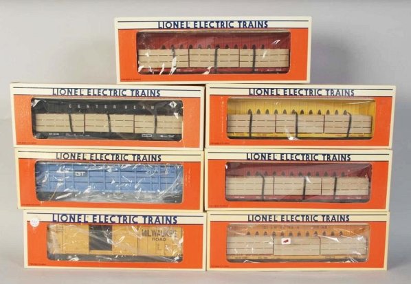 Lot of 7: Lionel Freight Train Cars.: Contemporary. Includes five flat cars, one auto carrier car, and one boxcar. Includes all original boxes with some wear. Condition (Excellent - Near Mint).