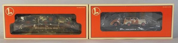 Lot of 2: Lionel Train Flat Cars with Vehicles.: Contemporary. Includes one with a Ford Wagon and trailer and one with two Corgi Mack trucks. Includes original boxes. Condition (Near Mint).