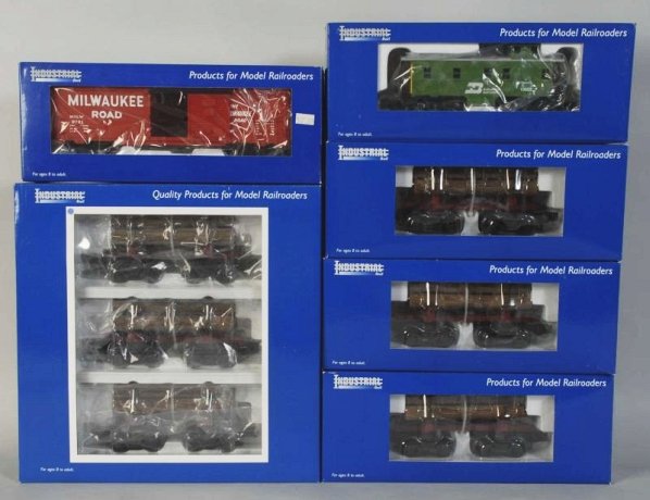 Lot of 6: Industrial Rail Freight Train Cars.: Contemporary. O27-gauge. Includes log cars, one boxcar, and one caboose. Includes all original boxes. Condition (Near Mint).