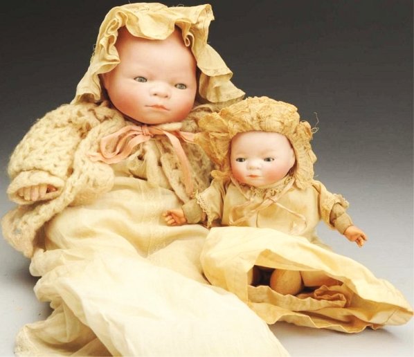 Lot of 2: "Bye-Lo Baby" Dolls.: Both with German bisque heads fully incised, solid dome heads and sleeping eyes; larger with cloth “frog” body with composition hands (peeling), original gown with undies, sweater and hat; smaller