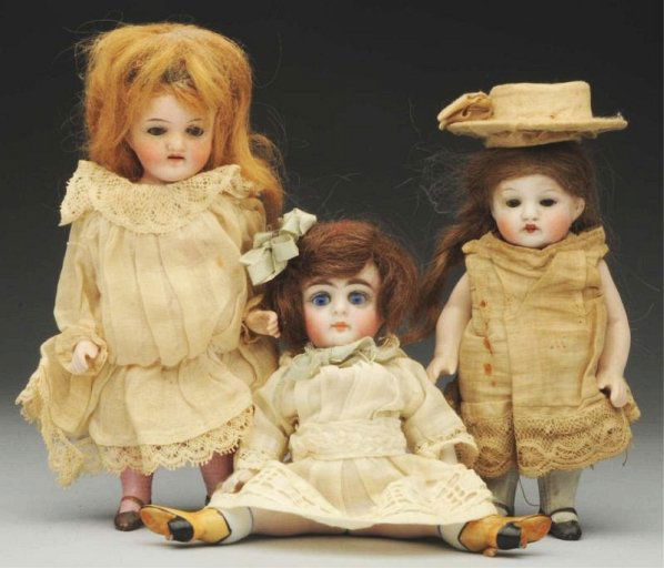 Lot of 3: German All-Bisque Dolls.: All with glass eyes, mohair wigs and jointed shoulders and hips. Small chubby Kestner with white stockings (needs cleaning); “4527” girl with pink stockings, original dress and limbs; Kestner 184
