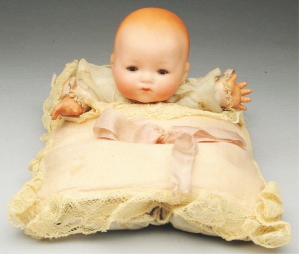 Original "Tee-Wee" Hand Puppet Doll.: German bisque head by Armand Marseille with glass sleeping eyes, closed mouth on a pillow with opening in the back for inserting your hand so that your fingers can move the baby’s head. All original