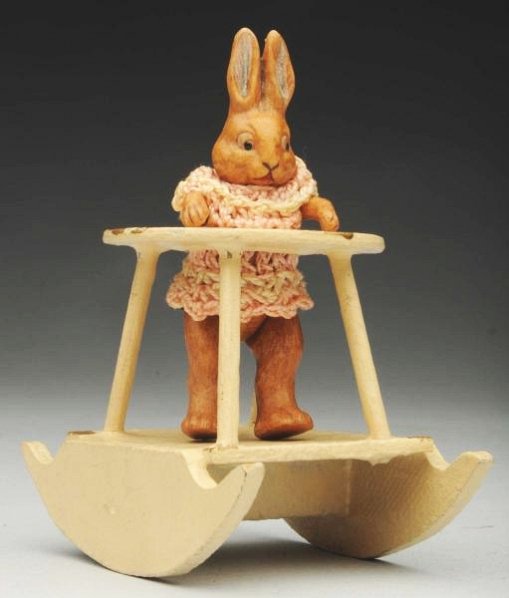 Rare German All-Bisque Rabbit.: Incised Germany on back. Antique Rabbit girl with jointed shoulders and hips, long ears and painted eyes; original pink crocheted dress. In a wood rocking baby chair. Very rare and desirable! Conditio
