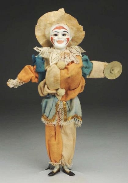 Clapping Clown Toy.: German white bisque character head incised “H. 1” with clown painting and wide smiling mouth, mohair wig; original wire and wood body with bellows to make hands clap and eyes close; original flann
