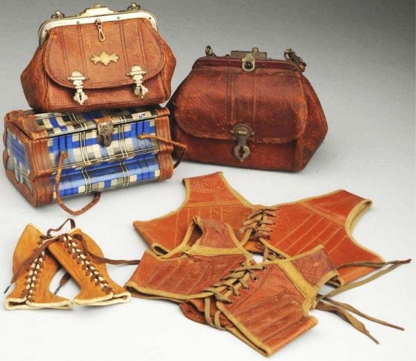 Lot of Antique Leather Goods.: Two leather vests or corsets, one marked “Superior Quality”; leather handbag with “Gladstone” written inside and metal fastenings; leather handbag with repaired handle; cardboard travelling ca