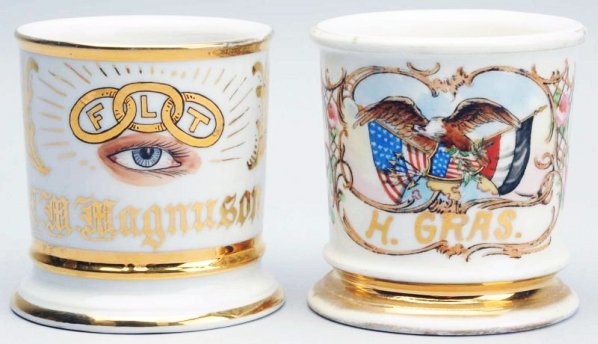 Lot of 2: Shaving Mugs.: The first is a patriotic mug and has "H. Gras" in gold gilt. Mug is stamped, Germany. No damages and moderate gold loss. The second is an Odd Fellows fraternal mug and has "C.M. Magnuson" in gold gilt