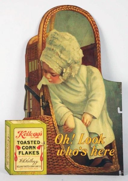 Kellogg's Corn Flakes Two-Sided Sign.: 1910. Manufactured by American Art Works, Coshocton, Ohio. Classic, showing baby in basket looking at box of Kellogg's Toasted Corn Flakes. Same image both sides. One side is excellent; other side is