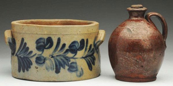 Lot of 2: Stoneware Pieces.: Includes one flat handle crock with a blue floral design and one bottom crack and one redware handled crock with no damage. Condition (Excellent). Size Largest: 8 - 1/4" Dia.Largest: 8 - 1/4" Dia.(Exc