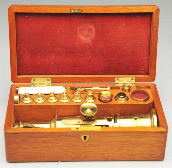 London Brass Compound Microscope in Wooden Box.: Appears to be complete with all lenses. Achromatic Compound Microscope Magnifier up to 20,000 times. Minimal wear. Condition (Excellent). Size Box: 10 - 3/4" x 5 - 1/2".Box: 10 - 3/4" x 5 - 1/2".(Exce