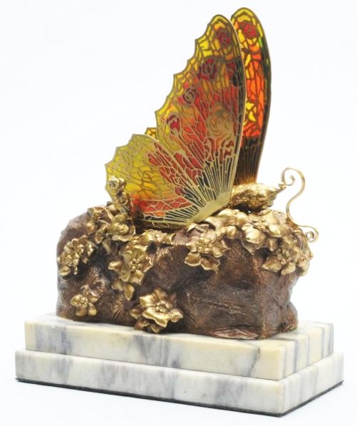 Metamorphic Brass & Marble Butterfly.: By Carl Kauba. 1865 - 1922. Austria. Copyright 1905. Brown and gold. Wings open slowly with clock movement. The hinged wings are filigree and plique-a-jour. Translucent enamel. Working. A quite rare p