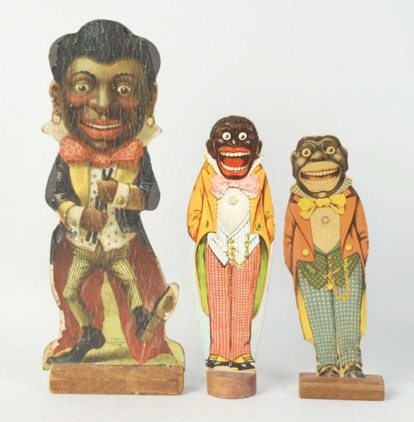 Lot of 3: Early Minstrel Game Pieces.: Two are from a ten pin set. The other one is marked copyright 1902 MCloughlin Bros. From three different sets. All are pressed cardboard and wood on wood bases. The largest one says," He is just Jim c
