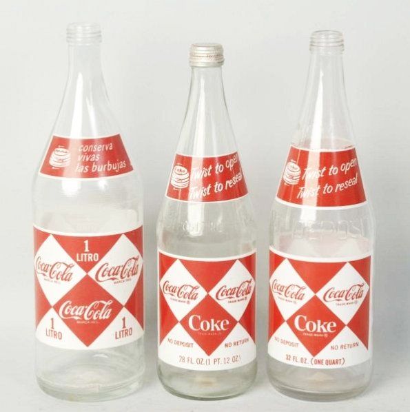 Lot of 3: Different Coca-Cola ACL Bottles.: A foreign liter, 28 oz. and 32 oz. Light wear on the group. Condition (Near Mint). Size Largest: 12" T.