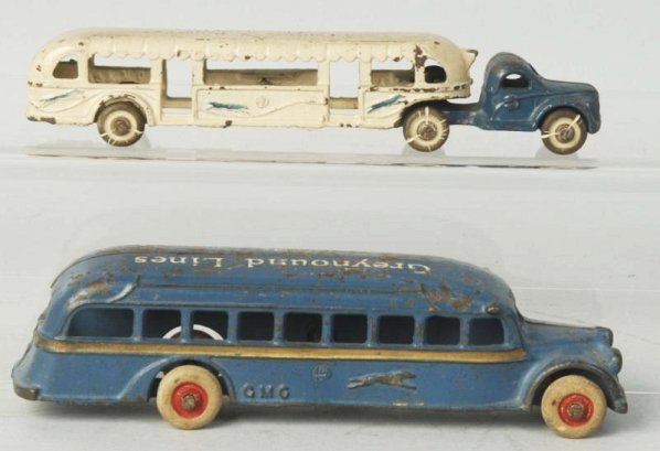 Lot of 2: Cast Iron Arcade Greyhound Bus Toys.: One says Greyhound Lines GMC on the top. Second is a tractor trailer made for the 1933 Chicago Worlds Fair. Both have white rubber tires. Some paint loss and wear. Especially to roofs. Condition (Very