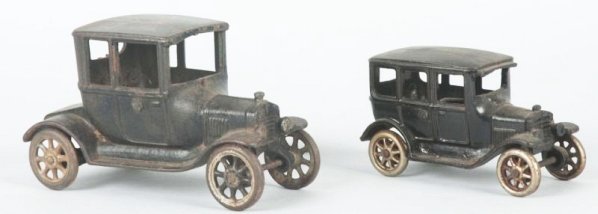 Lot of 2: Cast Iron Arcade Automobiles.: One missing driver both have metal wheels. One sedan, one coupe. Some paint loss and wear. Condition (Very Good). Size Largest: 6 - 1/2" L.