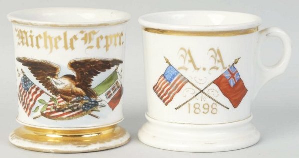 Lot of 2: Patriotic Shaving Mugs.: Has Crossed American Flag with bald eagle. Marked Michele Fepre. No stamps. Bright blue wrap all the way around the backside wit heavy gold decoration. Some gold has worn on top and bottom rims. Secon