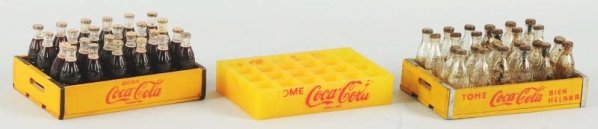 Lot of 3: 1940s-50s Coca-Cola Miniature Cases.: One empty plastic and two wooden cases lettering wear on plastic piece. Light soiling and cap rust on the wooden Tome case. Little wear and strong overall on the Beba case Condition (Very Good - Near 