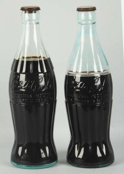 Lot of 2: 1930's Coca-Cola Display Bottles.: Christmas and Pat. D versions. Both with display fluids and marked caps. Both display with light cap wear and mild stains in the top of the Pat. D bottle. Condition (Excellent - Near Mint). Size Each: