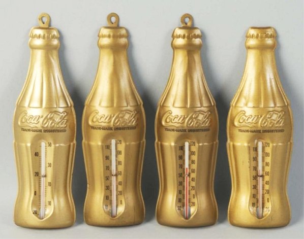 Lot of 4: 1950s Coca-Cola Gold Bottle Thermometer: All feature differing readouts. One has a broken hanging tab, with a replaced hanger glued on back and little wear on any. Condition (Near Mint). Size Each: 7- 1/2" T.