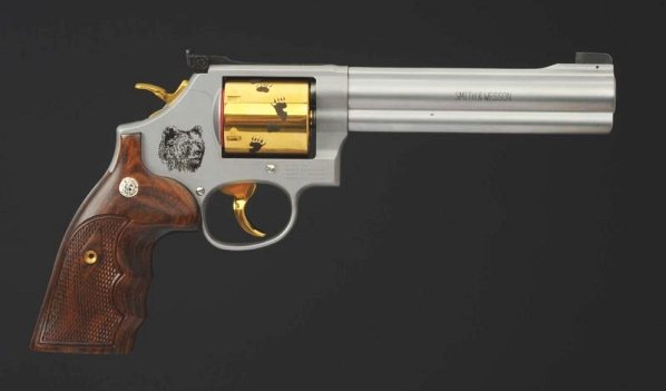 Smith & Wesson Model 686 .357 Cal.**.: Serial No.CMM7653. Barrel length 6". Clean, shiny bore. Special edition with gold trigger, hammer and cylinder. Cylinder has bear tracks. Bear head is engraved on right side of frame. Nice wooden targ