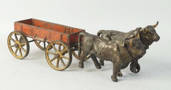 Cast Iron Ox-Drawn Red Wagon.: American made. No driver. Pulled by two stationery oxes. Some paint loss and wear to back especially to wheels. Condition (Very Good). Size 15 - 1/2" L.