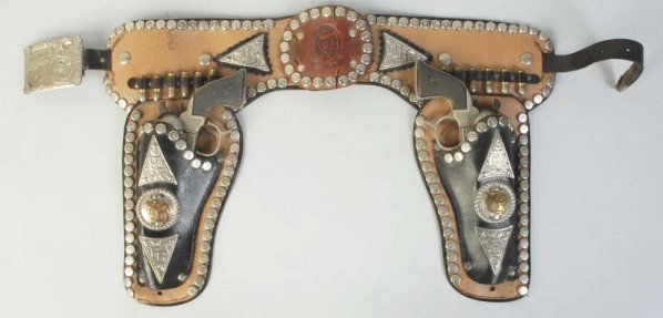 Roy Rogers Gun & Holster Set.: Both guns are used hard. Fired caps, finish loss. One not working at all. Holster is used. Repair on center piece and buckle needs a stud to hold it on the belt. Gun (Good). Holster (Very Good). Size