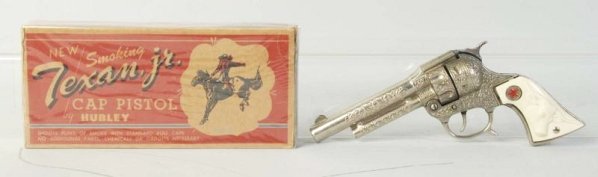 Hubley Texan Jr. Cap Gun.: Fired caps. Some finish wear especially on the hammer. Box is shrink wrapped. Gun (Very Good Plus). Box (Very Good Plus). Size 9 - 1/2" L.