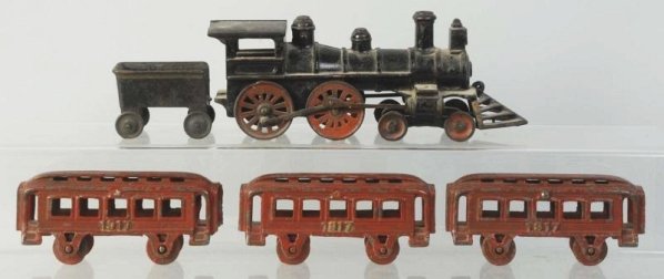 Early Cast Iron American Passenger Floor Train.: American style engine with cow catcher. Has a matching tender and three smaller passenger cars embossed "1917" on both sides in gold lettering. All original. Cars seem small for engine and tender and 