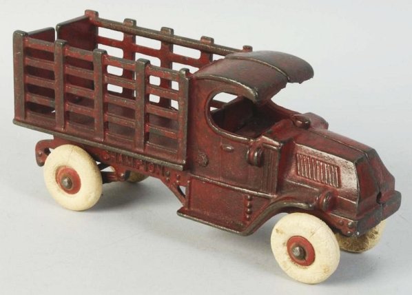 Cast Iron Champion Stake Back Truck.: Has original white rubber tires with some minor flat spots and cracking. Embossed "Champion" on both sides of back stake. Some paint loss and wear especially to cab roof and sides of stakes. Condition