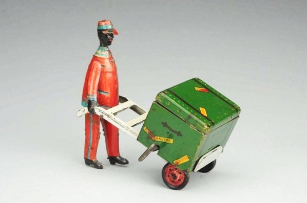 Strauss Tin Litho Wind-up Red Cap Porter Toy.: When operated, the trunk lid opens and the dog pops out. One side of porter figure has litho loss and some repaint. Condition (Very Good). Size 6 - 1/2" L.