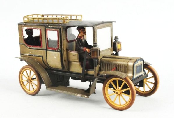 German Carette Clockwork Limousine Toy.: Looks to be all original including front head lights. White rubber tires. There are three hand painted passengers in rear of car. Original bevel glass windows some paint loss on rear right fender. Scr