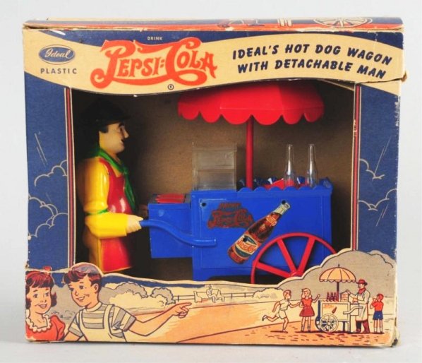 1940s Pepsi-Cola Toy Hotdog Wagon.: Great piece which is complete with original box. Only light wear on the box itself with a few closed tears and nearly no wear on the man or wagon. Condition (Near Mint). Size 9 - 1/4" L.