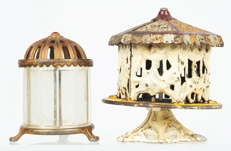 Lot of 2: Cast Iron Still Banks.: Includes a carousel and a glass receiver bank. Condition (Very Good). Size Largest: 5" T.