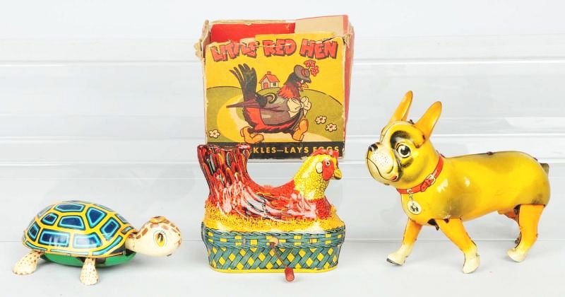 Lot of 3: Tin Litho Toys.: Includes one crank wind Little Red Hen which is missing wooden eggs. Has partial original box and is missing the top lid. Also includes a US Zone Germany Buloy dog, and a wind-up Japanese TPS turtle.