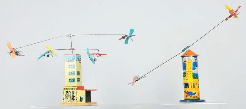 Lot of 2: German Airplane Tower Toys.: Toys are tin wind-ups. All original with original props. Includes an extra set of airplanes for one of the towers. Some scratching and wear throughout. Condition (Excellent). Size Largest: 10" T.