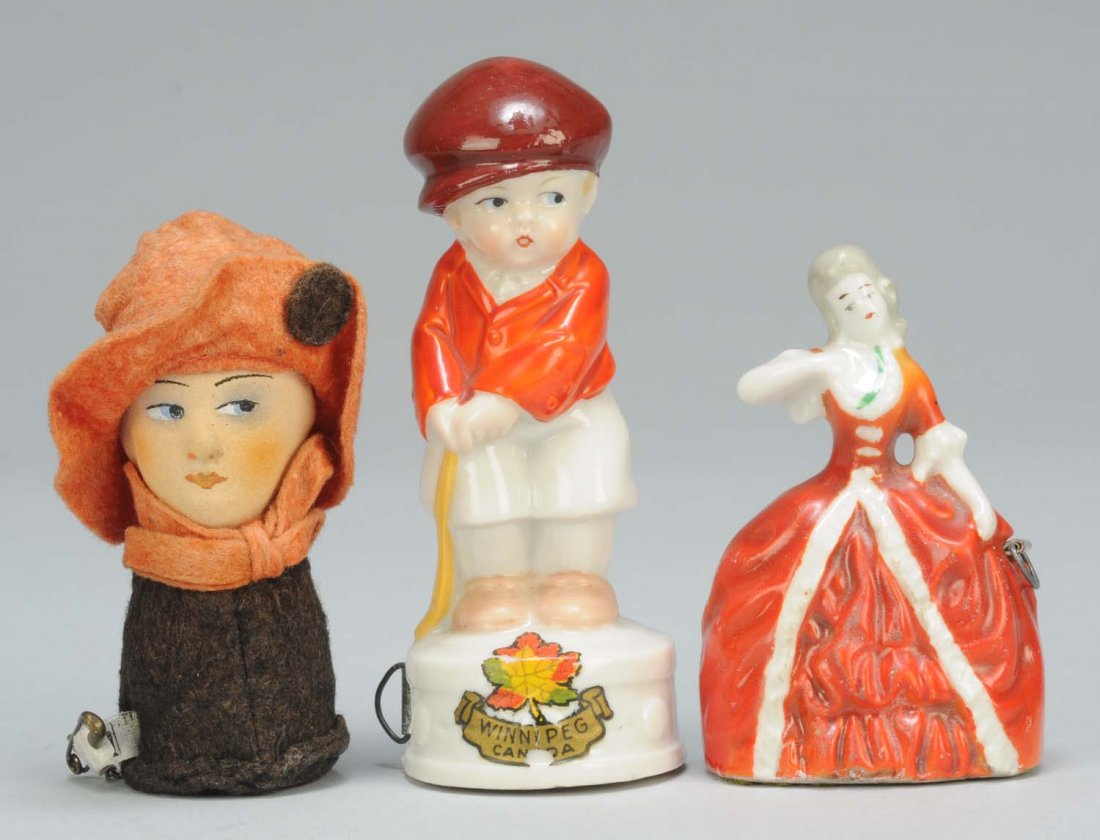 Lot of 3: Figural Sewing Tape Measures.: One is Art Deco lady with full spring tape and tab. Second, is a porcelain boy with cricket stick with full spring tape. Last, is a porcelain Victorian lady with full spring tape. Condition (Excellent