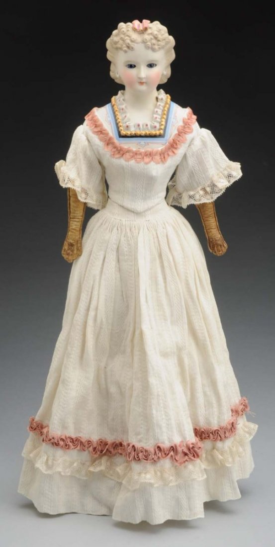 Enchanting Parian Lady Doll.: German shoulder head with light brown molded hair and applied rose and gold bow, applied decoration on shoulder plate (extensive repair to face and neck and to about 1” of neck ruffle and hair bow);