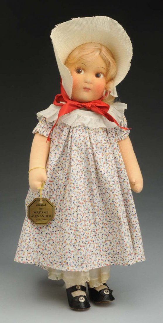 Sweet Alexander Cloth “Nell” Doll.: Mask face with painted side-glancing eyes, closed mouth, original blonde mohair wig; cloth body with jointed shoulders and hips; original tagged outfit with organdy trimmed dress and straw hat, organd
