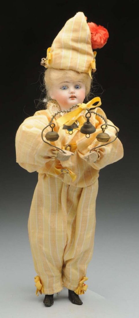 Cute Clown Novelty Toy.: Bisque head with glass eyes and mohair wig; wood torso with wired wood hands holding a wire with bells on it, wire upper legs and wood lower legs. Nicely redressed, cute little novelty item for one of
