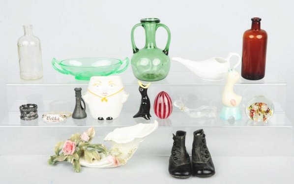 Lot of Assorted Glass.: Includes two paperweights, pharmacy bottles, a napkin ring, wall pocket, and other glass pieces. Also includes a pair of childs shoes. Minor chips. Condition (Excellent). Size Largest: 10 - 1/2" L.
