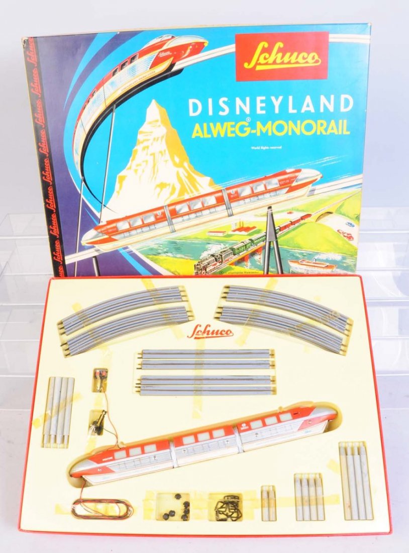 Schuco Disneyland Mono Rail Set in Box.: Red and green set. Includes is complete like new in original box with all the track and cars. Scotch tape that holds track in place is yellowed. Comes with original paper work. One corner of the set b