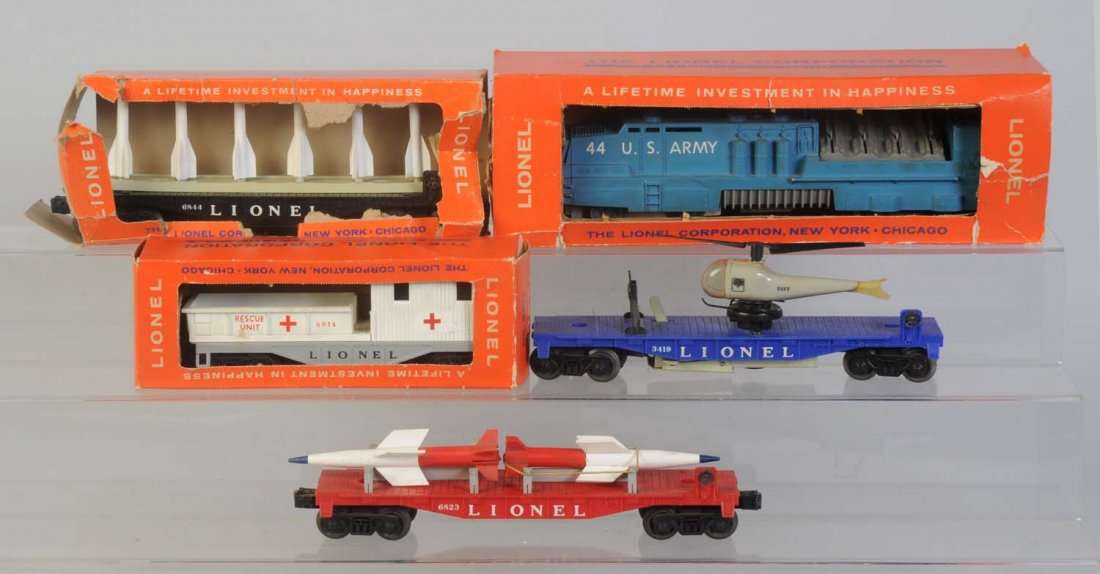 Lionel Assortment of Military Trains.: No.44 Mobile Army missile launching car in original box. Box is missing the display insert. Four steps are chipped on launcher. Missing front coupler. No.3419 helicopter launching car. Helicopter is d
